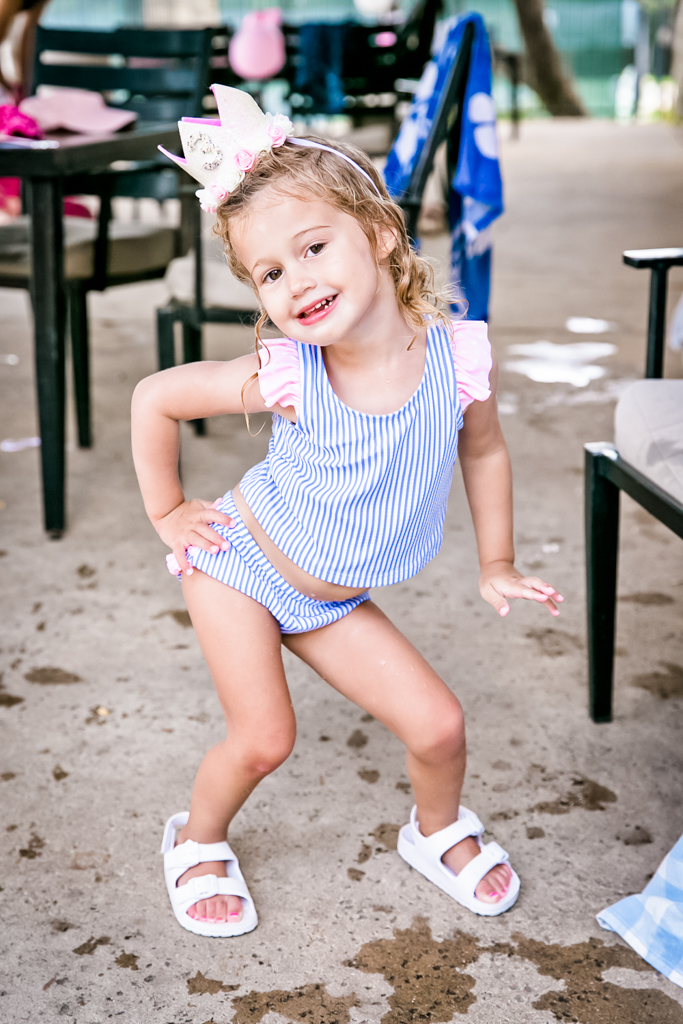 Annabelle striking a pose in her third birthday crown and Cinderella-themed swimsuit