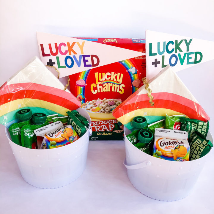 St. Patrick's Day Treat buckets for kids with green and rainbow treats and a "lucky + loved" pennant flag
